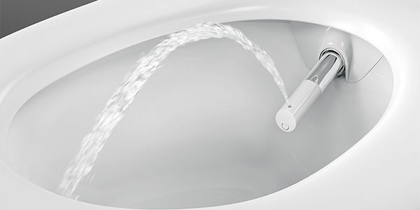Eine WC-Schüssel, aus der eine Vorrischtung kommt aus der ein Wasserstrahl zum Saubermachen kommt.