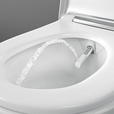 Eine WC-Schüssel, aus der eine Vorrichtung kommt, aus der ein Wasserstrahl zum Saubermachen kommt.