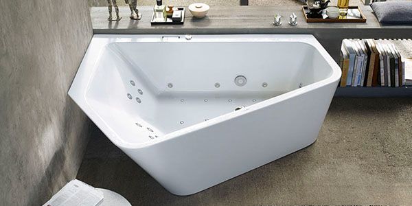 Eine asymmetrische Badewanne mit Whirlpoolfunktion.