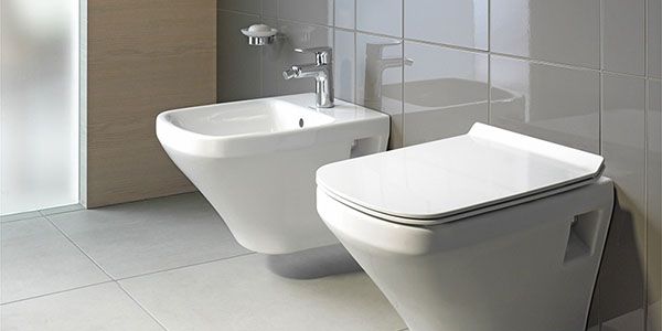 Ein Bidet neben einer Toilette.